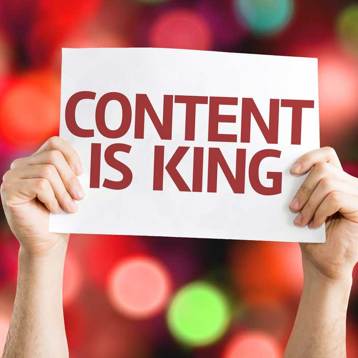 hands holding up a sign that says content is king