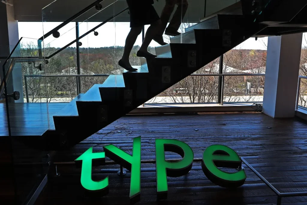 a green sign featuring monotypes old stock ticker symbol at its offices in woburn massachusetts. getty imagesboston globe