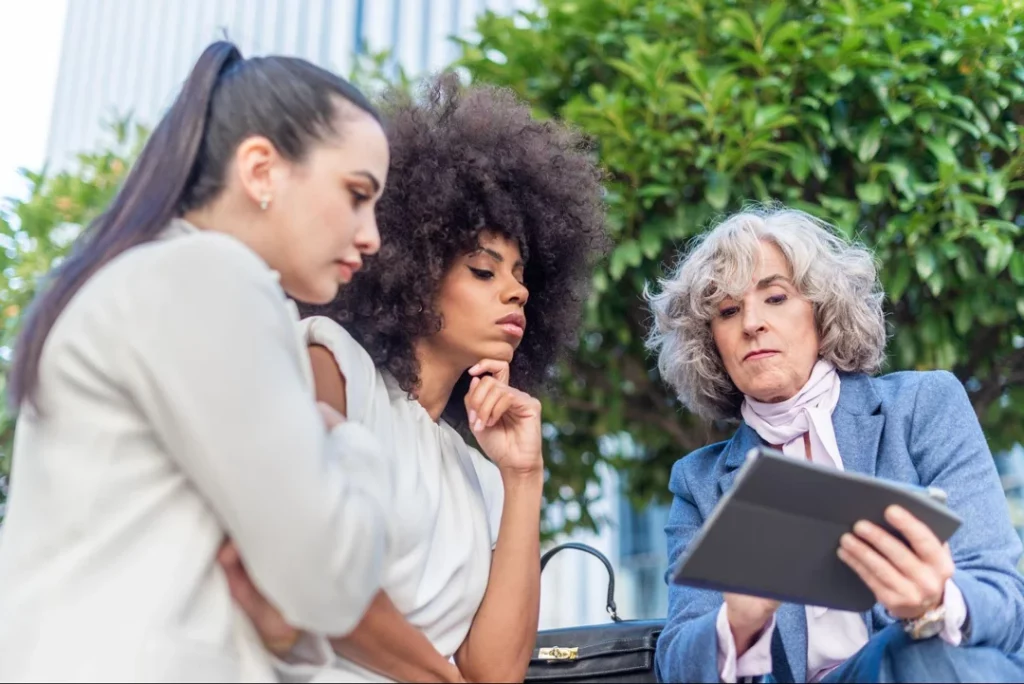 group of ladies looking at a business website on an ipad